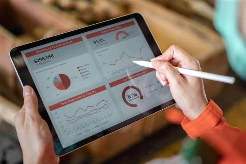Podnikatel kontroluje přehledy tržeb na tabletové pokladně